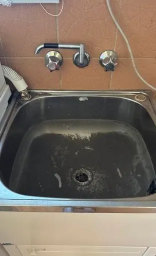 Stained laundry sink before cleaning